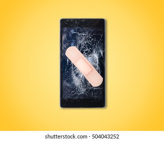 Mobile Smart Phone with cracked screen fixed with plaster on yellow