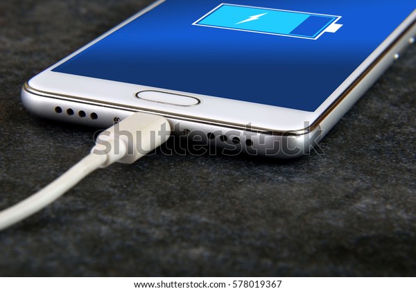 Mobile smart\
phones charging on rock\
background\
