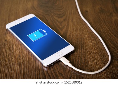 Mobile Smart Phones,phone Charging On Wooden Desk
