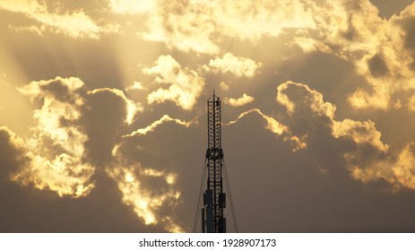 Mobile telecommunication tower during sunset with sun rays and clouds background at Saudi Arabia