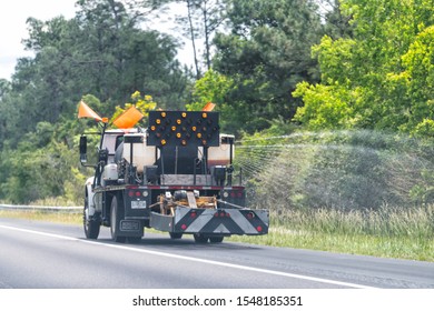 Mobile, USA - April 24, 2018: Alabama city with highway interstate 10 and closeup of truck spraying water watering green grass or herbicides