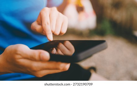 Mobile usage. Person using tablet device with finger touching screen, technology, digital communication, close up, outdoors, casual, modern lifestyle.