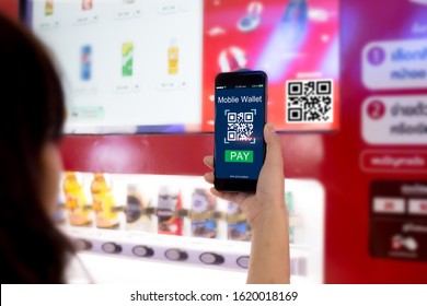 Mobile Wallet Concept.Woman Scanning QR Code Via Mobile Phone With Smart Vending Machine As Background