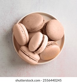 Mocha Mousse - color of the year 2025. French dessert macaroons, minimal concept flat lay. Stack of macarons, macaroons French cookie , trendy color toning