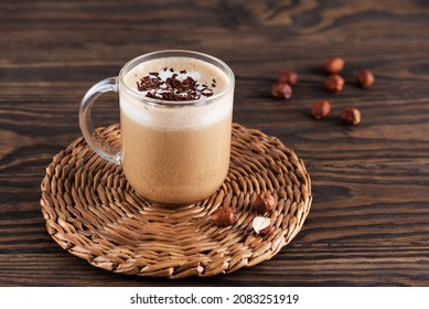 Mochaccino coffee with chocolate and coconut milk in a mug on a brown wooden table.