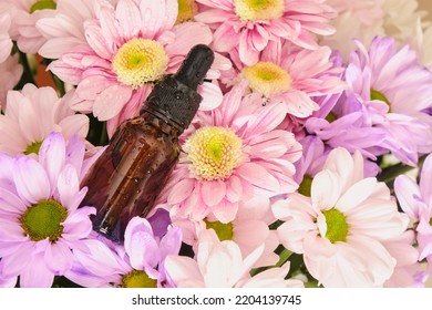 Mock Up Amber Glass Dropper Bottle With Serum Or Oil And Chrysanthemum Flowers