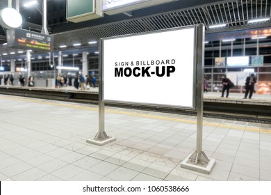 Mock Up Blank Billboard On Stainless Steel Case At Train Station Platform With Clipping Path, Perfective On White Screen For Advertising, Information To Public With Blurred Passenger Waiting Train