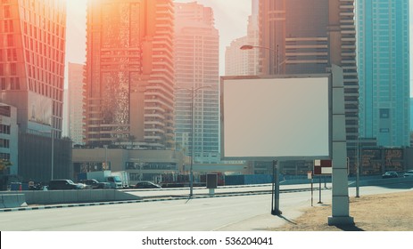 Mock Up Of Blank White Advertising Billboard In Dubai With Residential And Office Modern Contemporary Skyscrapers And Empty Highway Behind