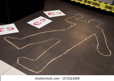 Mock Crime Scene With Yellow Ribbon And Chalk Body Outline.