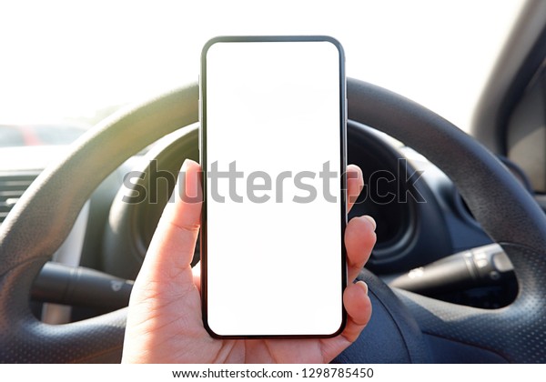 mock up driver\
hand holding phone in car  empty clear screen for text- advertise\
copy-space background-\
image.