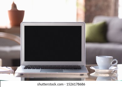 Mock Up Empty Black Laptop Screen On Blured Background With Cup Of Coffee. Copyspace, Negative Space For Your Advertising, Office And Business Style.