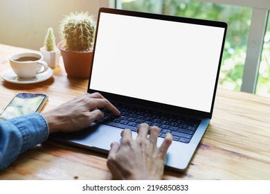 mock up empty screen notebook, businessman working on his laptop computer with blank space screen for advertising text on wood desk in Cafe