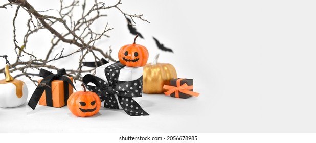 Mock Up Halloween Background With Gifts, Pumpkins And Scary Tree Branches On White. Halloween Trick Treat Concept For Greeting Card Or Sale Banner. Spooky Decorations With Copyspace.