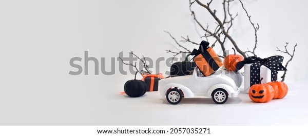 Mock
up Halloween decorations. Close up retro toy car with pumpkins,
gifts over tree branches. Creepy and funny concept. Halloween trick
treat greeting layout background for sale.
Banner.