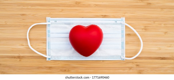 Mock Up Heart And Mask Prevent Coronavirus. Medical Hygienic On Wood Background. Protection Flu Against. Pandemic Virus Disease. Healthcare Covid 19 Outbreak Contamination Hygiene Concept. Copy Space.