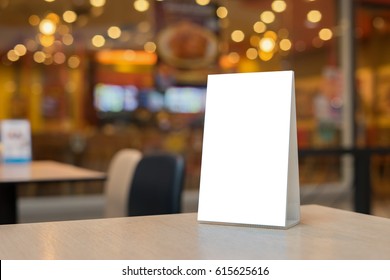 Mock up Label the blank menu frame in Bar restaurant ,Stand for booklets with white sheets paper acrylic tent card on wooden table cafeteria blurred background can inserting the text of the customer. - Shutterstock ID 615625616