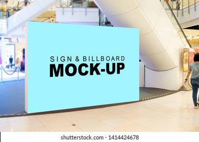 Mock Up Large Blank Billboard With Clipping Path Placed On Walkway In Shopping Mall And Blurred People Walking In Background, Empty Space For Advertising Or Information, Advertising Concept

