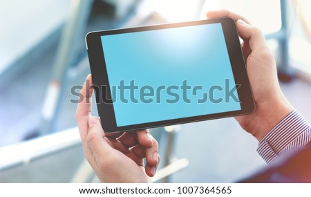 Mock up of a man holding digital tablet device in hands. Clipping path