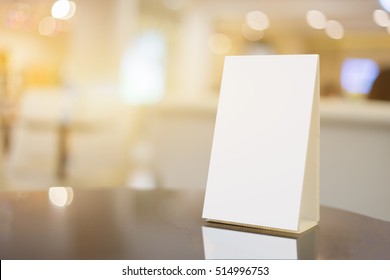 Mock Up Menu Frame On Table In Bar Restaurant ,Stand For Booklets With White Sheets Of Paper Acrylic Tent Card On Cafeteria Blurred Background
