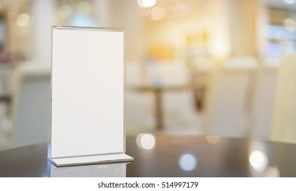Mock up Menu frame on Table in Bar restaurant ,Stand for booklets with white sheets of paper acrylic tent card on cafeteria blurred background
 - Shutterstock ID 514997179