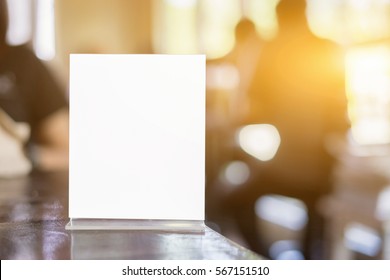 Mock Up Menu Frame On Table In Bar Restaurant ,Stand For Booklets With White Sheets Of Paper Acrylic Tent Card On Cafeteria Blurred Background 