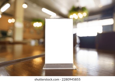 Mock up Menu frame standing on wood table in Bar restaurant cafe. space for text. Menu mack up blank for text marketing promotion