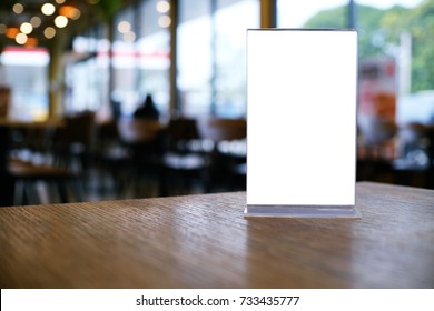 Mock up Menu frame standing on wood table in Bar restaurant cafe. space for text.