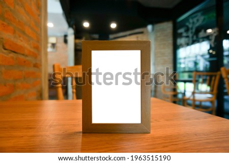 Mock up Menu frame standing on wood table in Bar restaurant cafe. space Menu mack up blank for text marketing promotion