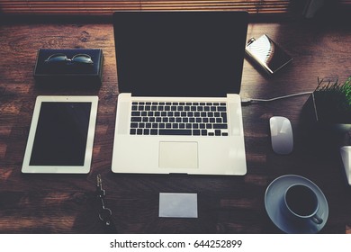 Mock Up Of Office Or Home Desktop With Gadgets And Work Tools, Blank Screen Portable Laptop Computer, Mouse, Sunglasses, Digital Tablet, Empty Touch Pad, White Envelope, Modern Hipster Workspace