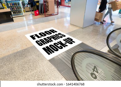 Mock up perspective blank square screen on floor with clipping path at front of escalator in shopping mall, empty space for insert graphic or text information or warning word, Blurred people walking