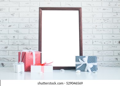 Mock Up Of Photo Frame And Gift Christmas Boxes, White Brick Wall On The Background, Blank Vintage Photo Frame