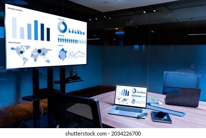 Mock up sales summary slide show presentation on display television and laptop with notebook on table in meeting room - Shutterstock ID 2034226700