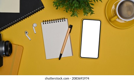 Mock Up Smart Phone, Notepad, Wireless Ear Phones And Coffee Cup On Yellow Background.