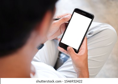Mock up smartphone of hand holding black mobile phone with blank white screen.  - Shutterstock ID 1546932422