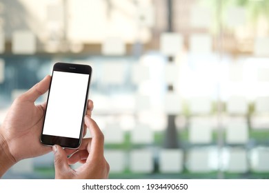 Mock up smartphone of hand holding black mobile phone with blank white screen. - Shutterstock ID 1934490650
