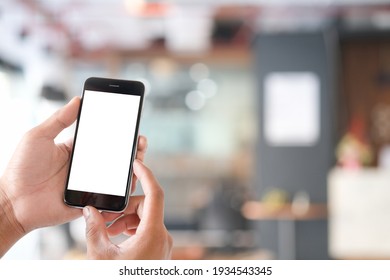 Mock Up Smartphone Of Hand Holding Black Mobile Phone With Blank White Screen.