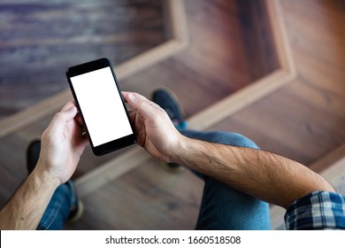 Mock up of a smartphone in man's hands, view from behind his shoulder. Clipping path included.