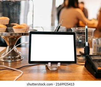 Mock Up Tablet Like IPad Stand On The Wooden Desk In Cafe Background With White Screen Clipping Path. 