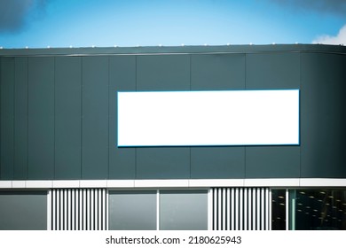 Mock Up Template. Big Horizontal White Blank Signboard, Advertising Billboard On Modern Building Wall Outdoors