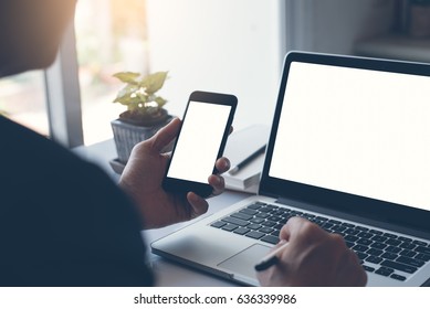 Mock Up, Businessman Holding Blank Screen Mobile Smart Phone And Browsing Internet On Laptop Computer In Office, Devices Data Transfer Linked, Cloud Storage Technology Concept