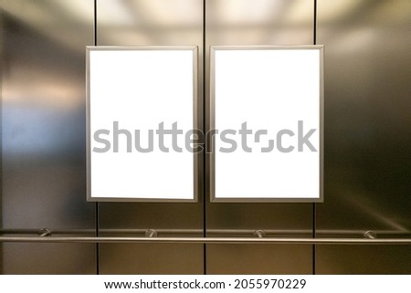 Mock up. Two vertical poster media template frame hanging on the wall in elevator lift