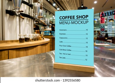 Mock Up Vertical Blank Menu In Coffee Shop With Clipping Path In Acrylic Frame Placed On Counter Bar, Blue Screen Empty Space For Insert List Menu And Price 