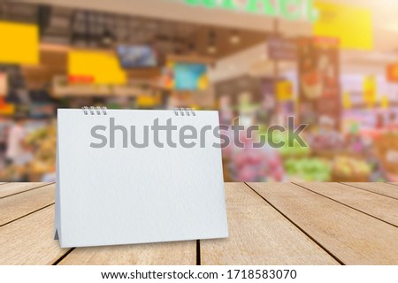 Mock up white acrylic frame posters pattern template blank menu put on old wood table in supermarket for your text of display your product and promotion.