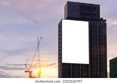 Mock up white background billboard on building, clipping path for Mockup. A large empty billboard on a city background in the middle of the sunset.