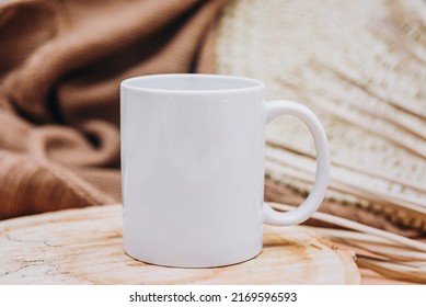 Mock up of white blank coffee mug perfect for your own design or quote on brown cozy background. Copy space.