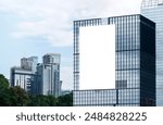 Mock up white vertical large LED display billboard on tower building with blue sky background .clipping path for mockup