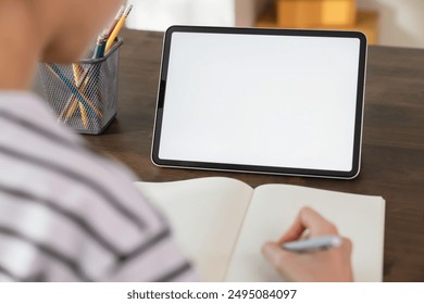 Mock up of woman hand holding digital tablet and touching blank screen. - Powered by Shutterstock