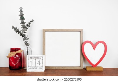 Mock up wood frame with Valentines Day heart decor and calendar. Wood shelf against a white wall. Copy space. - Powered by Shutterstock