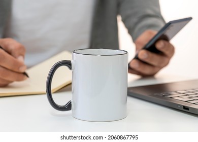 Mockup Of 11oz White Ceramic Mug With Black Handle With Copy Space For Your Design. Businessman Working On Background