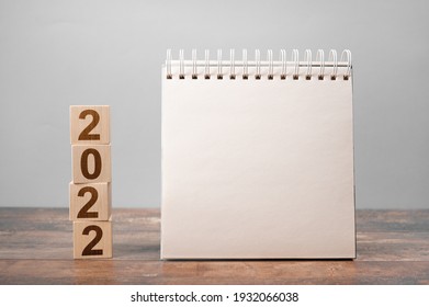 Mockup 2022 Calendar. Text 2022 On Wooden Cubes. Space For Your Text On Notepad, Mockup Calendar. New Year. Startup Concept